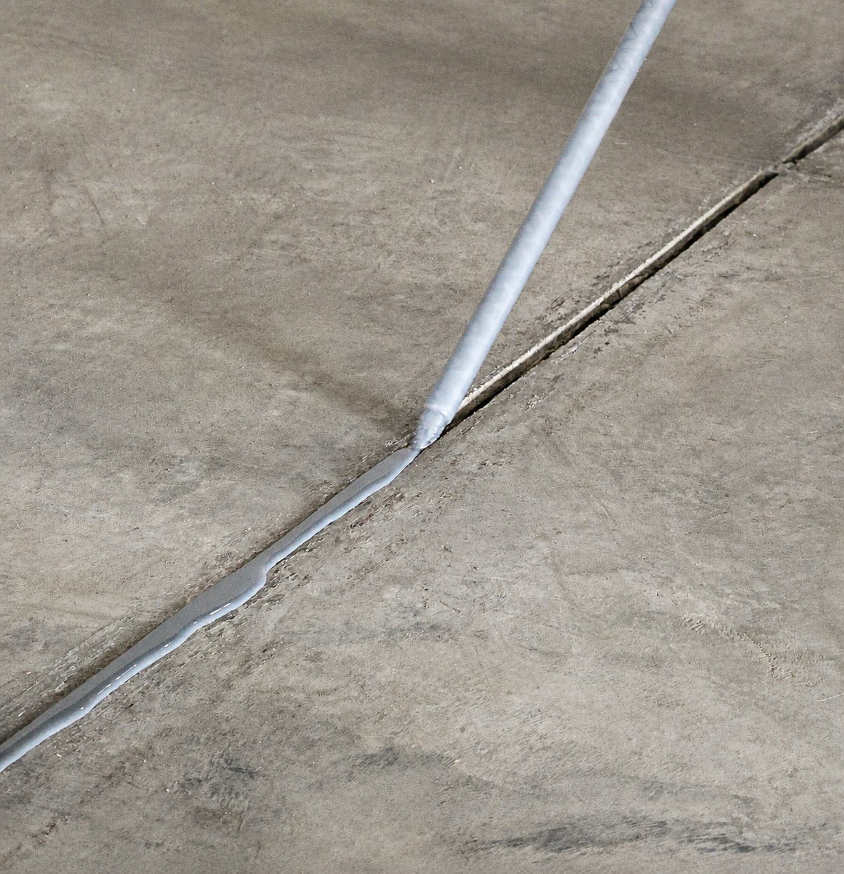 Joint material being applied along an industrial concrete floor joint